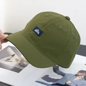 Détail de la casquette olive à bord court avec étiquette logo montagne pour l'extérieur