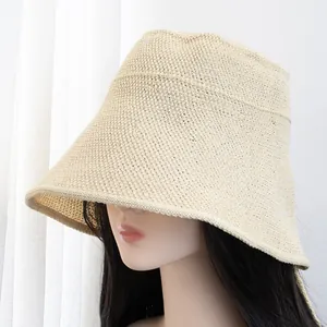 Detailed close-up of beige woven wide-brim straw hat with dense sun-protective texture