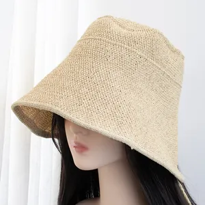 Detail of light beige woven sun hat with wide brim on mannequin against white background
