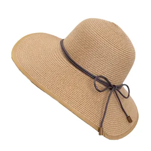Wide brim straw sun hat with decorative brown bow tie and UV protection for beach travel