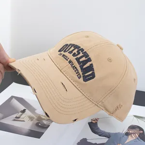 Close-up of distressed khaki cotton baseball cap with embroidered OUTSTAND lettering