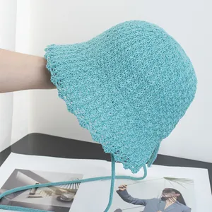 Detail of light blue crochet sun hat featuring hollow knit texture and wavy lace edge