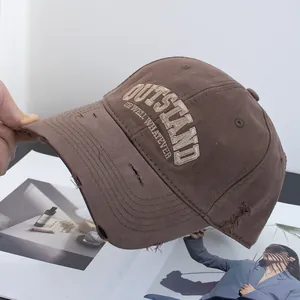 Close-up of brown vintage distressed cotton baseball cap with embroidered lettering detail