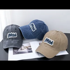 Detalle de gorras de béisbol de algodón lavado en colores antracita, azul denim y caqui