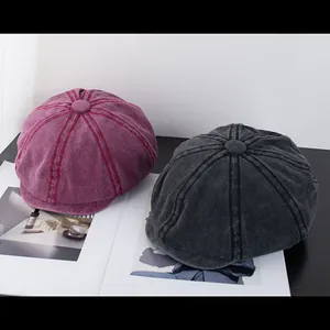 Detail view of burgundy and grey washed cotton newsboy hats with premium stitching