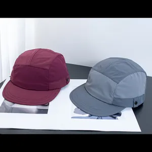 Detail von dunkelroten und schiefergrauen 5-Panel-Nylonkappen mit Ripstop-Textur