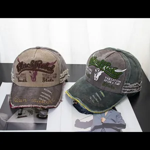 Close-up of distressed denim baseball caps with Black Rebel embroidery and frayed edges