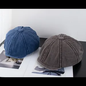 Close-up of navy and grey washed cotton newsboy hats with vintage fabric textures