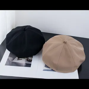 Détail de bérets noir et kaki empilés avec des coutures classiques à huit panneaux