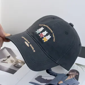 Close-up of cute rabbits embroidery and lettering on dark grey cotton baseball cap