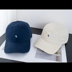 Detail von dunkelblauen und cremeweißen Baseballkappen mit R-Stickerei auf Magazinen