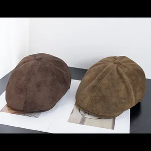 Vista dettagliata di berretti newsboy in pelle scamosciata marrone e verde oliva