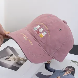 Detailed embroidery of cute cartoon bunnies on a dusty pink cotton baseball cap