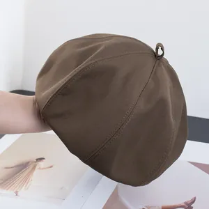 Détail du béret en sergé de coton marron foncé avec boucle vintage et couture nette