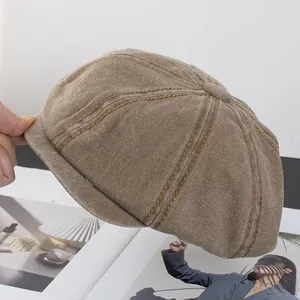 Detailed close-up of brown corduroy fabric and stitching on a classic baker boy cap