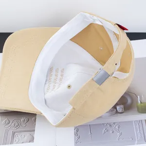Inside view of a khaki cotton baseball cap showing internal embroidery and adjustment buckle