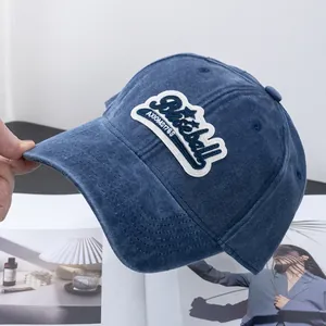 Detalle de gorra de béisbol de algodón azul con bordado y acabado lavado