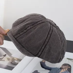 Detail view of washed cotton fabric and panel stitching on a charcoal grey newsboy cap