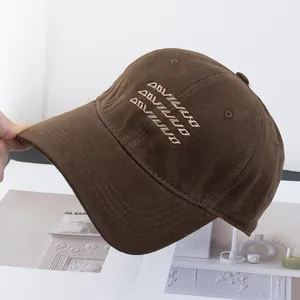 Detailed embroidery texture on dark brown cotton twill baseball cap with white lettering