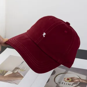 Nahaufnahme der dunkelroten Baseballkappe mit weißem R-Buchstaben-Stickereilogo