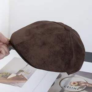 Dettaglio ravvicinato del cappello da strillone in camoscio marrone scuro con bottone