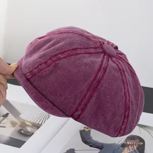 Close-up of retro burgundy newsboy cap with contrast stitching and corduroy texture