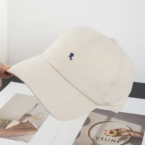 Nahaufnahme der beigen Baumwoll-Baseballkappe mit dunkelblauer R-Stickerei und Nähten