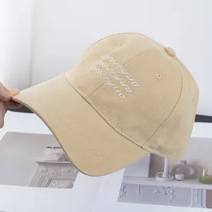 Macro view of beige cotton baseball cap with white cursive embroidery and twill texture