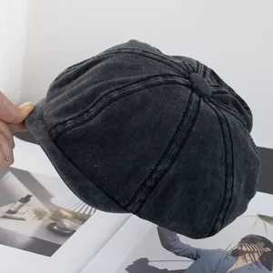 Close-up of black washed cotton newsboy cap with classic eight-panel stitched design