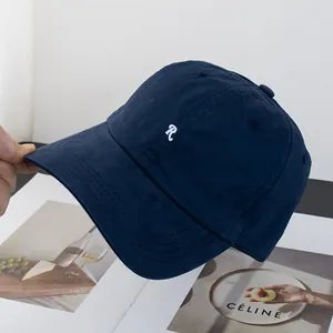 Detailansicht der R-Stickerei und Baumwollstruktur auf der dunkelblauen Baseballkappe