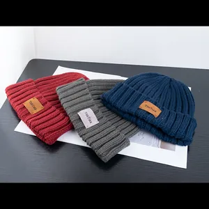 Winter chunky knit beanie hats in red, gray and blue with vintage leather patch decor
