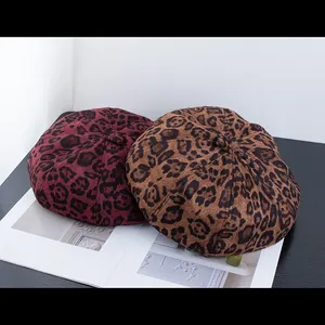 Detail of vintage leopard print berets in burgundy and brown textured wool fabric