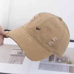 Vue détaillée du tissu en coton vintage vieilli et de la petite broderie de la lettre W sur la casquette