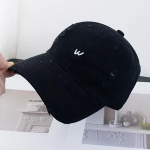 Détail de la casquette rétro noire avec broderie W blanche et finitions usées vintage