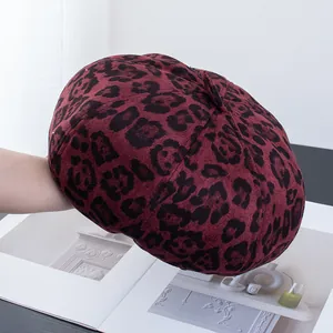 Detailed texture of burgundy leopard print beret with classic retro cloud-shaped design