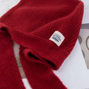 Detalle de cerca de pasamontañas rojo de punto con textura de lana gruesa y etiqueta blanca