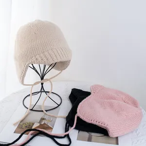 Rosafarbene und beige grob gestrickte Fliegermütze mit Ohrenklappen und Bindeband