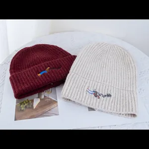 Bonnets en tricot bordeaux et crème avec broderie de chien mignon pour l'hiver