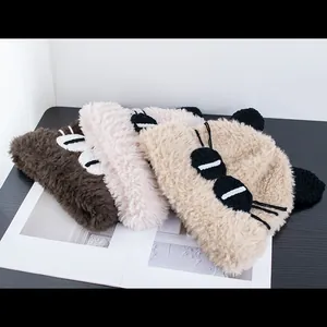 Dettaglio di cappelli in maglia peluche a forma di gatto in marrone, beige e kaki