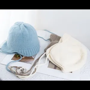 Detailansicht von Strickmützen in Blau, Beige und Braun mit süßen Katzenohren