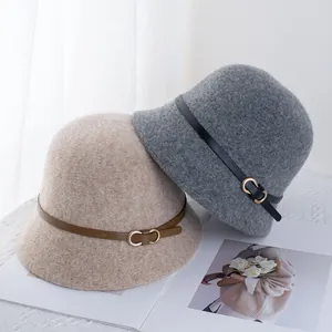 Dettaglio di cappelli cloche in lana con fibbia in pelle nei colori beige e grigio
