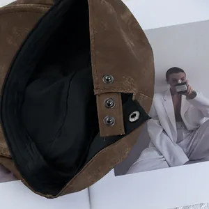 Brown faux leather beret featuring adjustable silver metal snap buttons and black lining