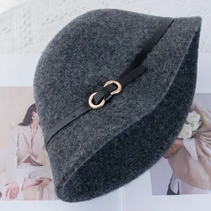 Dettaglio del cappello in lana con cinturino in pelle nera e fibbia in metallo dorato