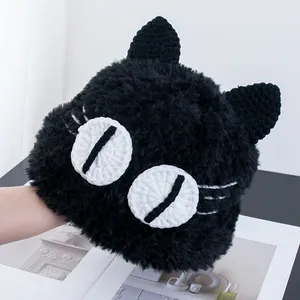 Dettaglio del berretto nero a forma di gatto con grandi occhi e texture soffice