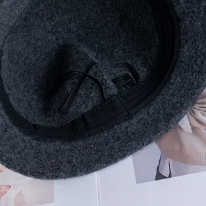 Dettaglio interno del cappello in lana grigio scuro con fascia e etichetta 100% lana