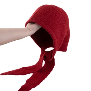 Pasamontañas de punto rojo para mujer con cintas largas y textura de lana sobre blanco