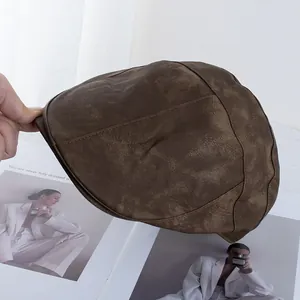Detailed view of the vintage brown PU leather texture and hand-stitched seams on beret