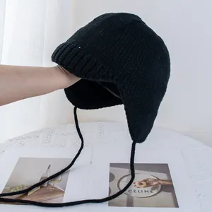 Nahaufnahme der schwarzen Strickmütze mit Ohrenklappen und langen Bindebändern