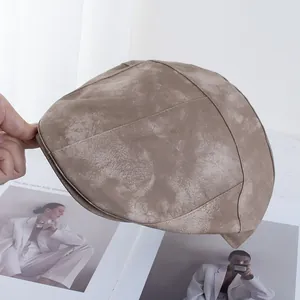 Detail view of brown PU leather flat cap with matte texture and vintage stitching