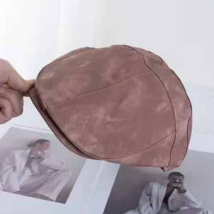 Detail shot of brown PU leather newsboy cap with premium matte finish and stitching